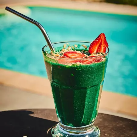 Glas mit 1 kg Bio-Spirulina-Pulver und Strohhalm