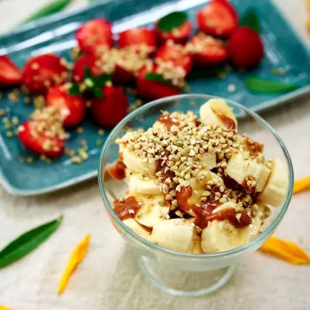 Bio-gekeimter Buchweizen-Dessert mit Banane, Karamell und gesunden Erdbeeren.